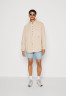 Tommy Hilfiger THXSM ARCHIVE OVERSHIRT UNISEX Button-down blouse tuscan beige THXSM ARCHIVE OVERSHIRT UNISEX Блузка на пуговицах тосканский бежевый