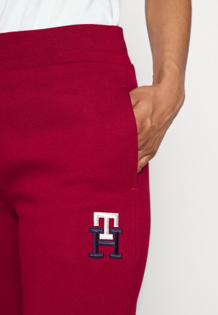 Tommy Hilfiger TAPERED MONOGRAM SWEATPANTS Tracksuit bottoms rouge СПОРТИВНЫЕ БРЮКИ TAPERED MONOGRAM Спортивные штаны румяна