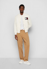 Tommy Hilfiger TOMMY HILFIGER X SHAWN MENDES COTTON VARSITY BOMBER EXCLUSIVE UNISEX Bomber Jacket weathered white TOMMY HILFIGER X SHAWN MENDES ХЛОПКОВАЯ КУРТКА-БОМБЕР ЭКСКЛЮЗИВ УНИСЕКС Куртка-бомбер выветрившийся белый